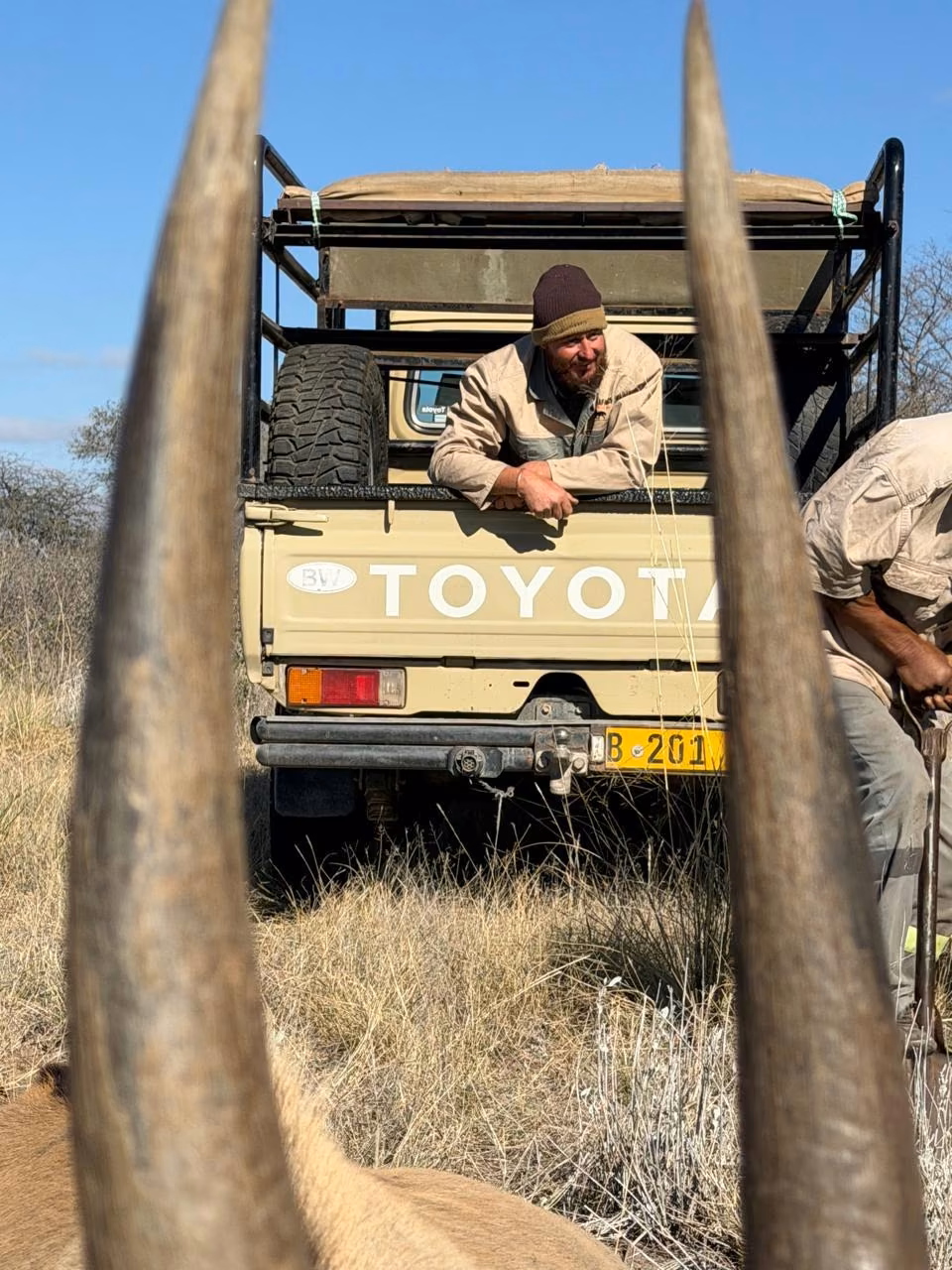 A Hunter Troopers professional hunter and tracker with the field vehicle after a Kalahari hunt